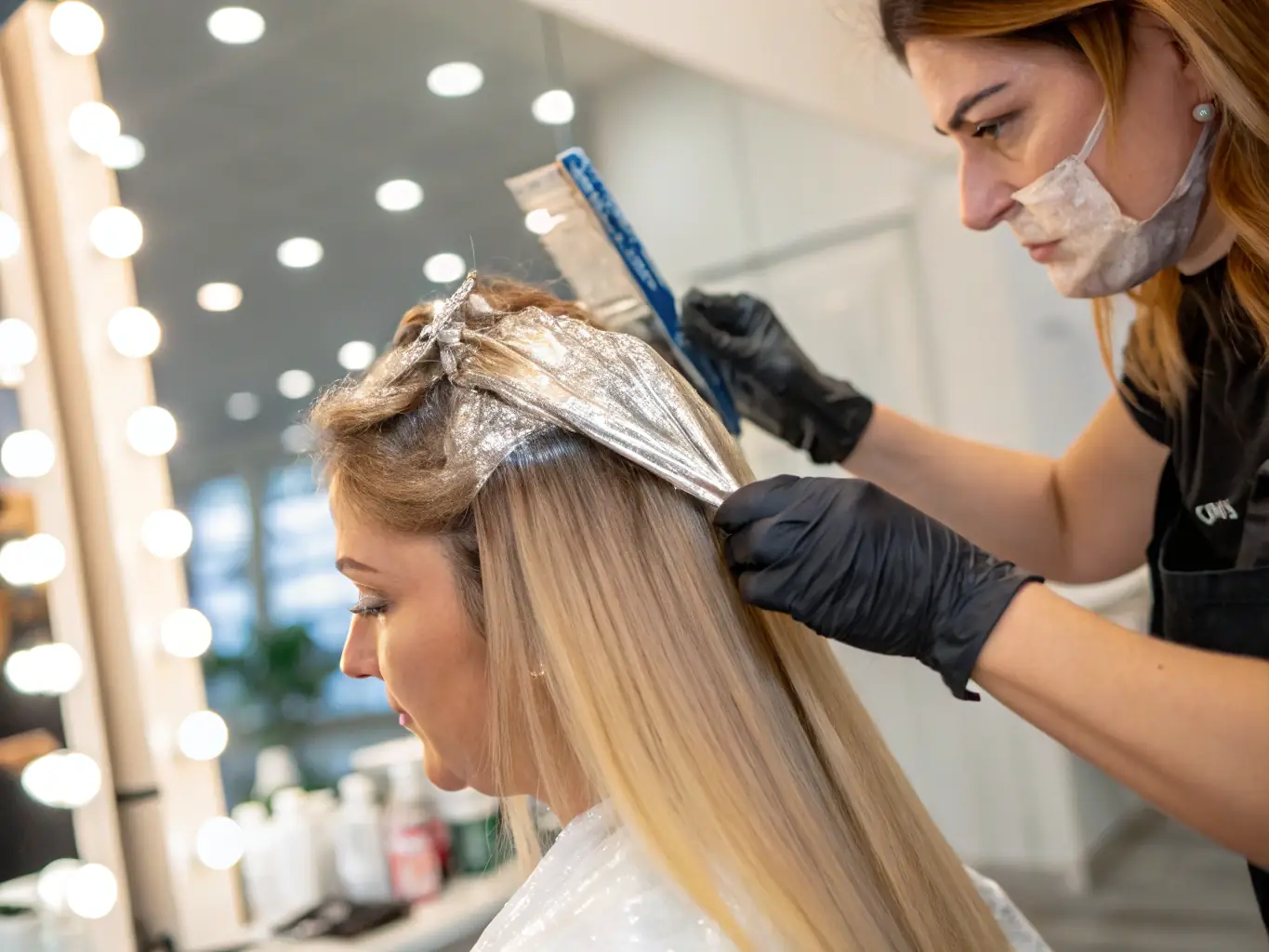 A vibrant image showcasing a stylist applying a balayage color treatment to a client's hair in a modern salon setting, emphasizing the salon's expertise in color services.